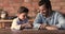 Young father and little clever son play checkers game