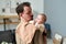 Young father looking at adorable baby son on his shoulder covered with napkin