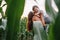 Young father, mother cute baby walking nature road near cornfield holding hands in summer