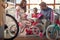 Young father and mother shopping new bicycle for little child in bike shop