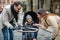 Young father and mother with son in baby stroller outdoors