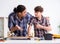 Young father repairing skateboard with his son at home