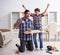 Young father repairing skateboard with his son at home