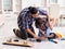 Young father repairing skateboard with his son at home