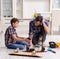 Young father repairing skateboard with his son at home