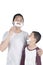Young father shaving his beard with son