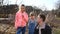 A young father teaches children to prune the bushes in the garden on a spring day. The concept of spring tree pruning and garden