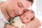 Young father tenderly holding newborn