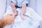 Young father touches his newborn son`s small foot while he sleeps