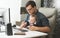 Young father working at home with his baby boy
