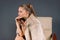 Young fearless businesswoman has a confident telephone conversation while sitting in armchair on a gray background