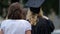 Young female in academic dress and loving mother excited before diploma awarding