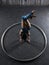 Young female acrobat standing on hand inside big metal hoop