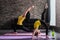 Young female adult doing crescent lunge pose and girl child standing in one-legged inverted staff position during yoga