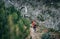 Young female backpacker enjoying white dry forest while trekking by famous mountain footpath from Pico do Arieiro to Pico Ruivo on