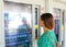 Young female backpacker tourist choosing a snack or drink at vending machine in Venice, Italy. Vending machine with girl