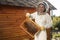 Young female beekeeper hold wooden frame with honeycomb. Collect honey. Beekeeping concept