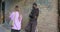 young female is being stalked by man criminal on the street, steal the smartphone