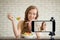 Young female blogger and vlogger and online influencer live streaming a cooking show on social media using a smartphone