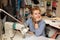 Young female blonde dressmaker cloth designer works on sewing machine. In her workspace. dress manufacturing industry