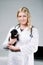 Young female blonde veterinarian holding a cute pug puppy