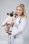 Young female blonde veterinary holding a cute beatiful pug