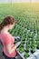 Young female botanist examining seedlings in plant nursery