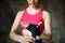 Young female boxer preparing for boxing fight. Athletic woman wearing strap on wrist before boxing practice in gym