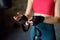 Young female boxer preparing for boxing fight. Athletic woman wearing strap on wrist before boxing practice in gym