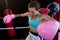 Young female boxer sitting in corner of boxing ring