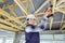 Young female builder working on wooden roof joist