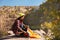 Young female camper unpacking sleeping bag in wilderness.