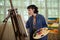 A young female carpenter working as wood designer in a small carpentry workshop. Young business woman handcrafting a