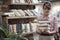 Young female carrying pile of books with both hands trying to blow hair from her face