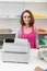 Young female cashier with cash register