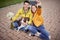 Young female in casual outfit with ripped jeans on her knee taking selfie of herself and a boyfriend sitting with legs crossed and