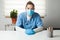 Young female caucasian General Practitioner sitting by her desk in office