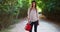 Young female Caucasian motorist carrying red jerrycan standing on isolated road