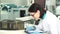 Young female chemist taking notes at the modern laboratory