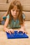 Young female child works on an over-sized calculator