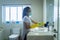 Young female cleaning bathroom with disinfectant