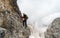 Young female climber on a steep and exposed rock face climbing a Via Ferrata