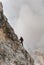 Young female climber on a steep and exposed rock face climbing a Via Ferrata