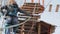 Young female climber walks by pendant log bridge on high ropes course in extreme park