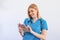 Young female clinician doctor in scrubs using touchpad while communicating with patients online. Portrait Of Smiling Female Doctor