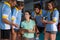 Young female coach talking with volleyball players