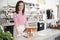 Young female coffee shop owner smiling behind the counter