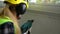 Young Female construction worker drilling concrete wall with a drill and smiling at the camera.