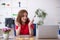 Young female designer having breakfast in the office