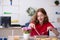 Young female designer having breakfast in the office